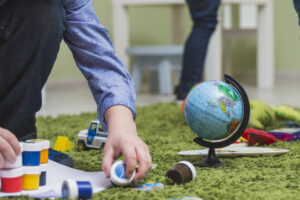 Niño jugando con pinturas y un mapa mundial